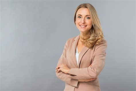 Souriant Portrait D Une Jeune Femme Blonde Confiante Debout Sur Un Fond Gris Photo Gratuite