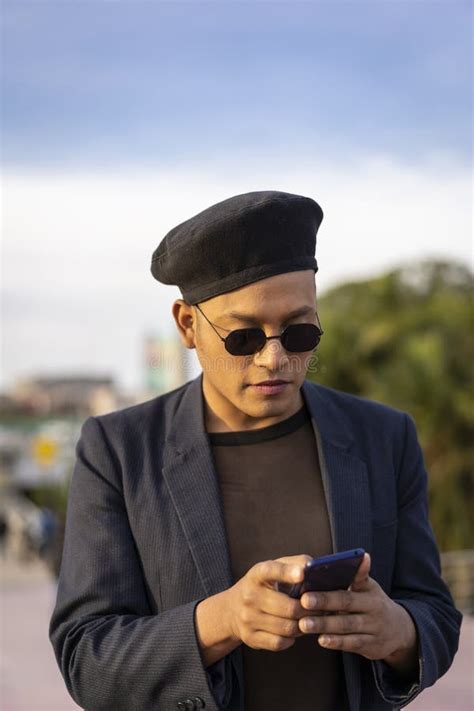 Latino Gay Male With Makeup On Wearing Trendy Hat Looking At Cell Phone Stock Image Image Of