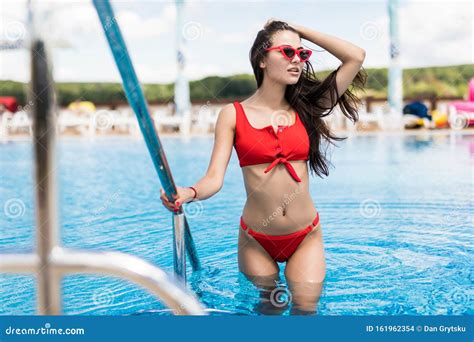 Elegant Woman In The White Bikini On The Sun Tanned Slim And Shapely