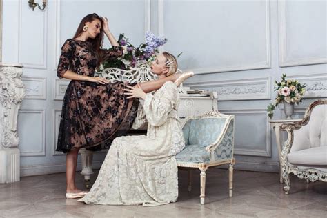 Joven Y Bonita Bailarina De Ballet De Brunette En El Piano Con Mujer Rubia En El Lujoso Estilo