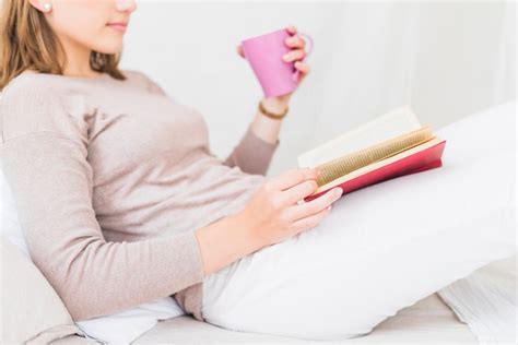 Vue Latérale De La Jeune Femme Assise Sur Le Lit Livre De Lecture