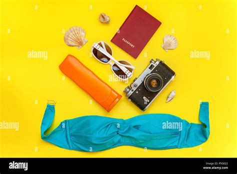 Flat Lay With Bikini Plane Vintage Camera Passport Sunscreen Sunglasses And Shell On Yellow