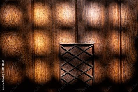 Detalhe de porta de madeira iluminada pela luz do sol que passa através