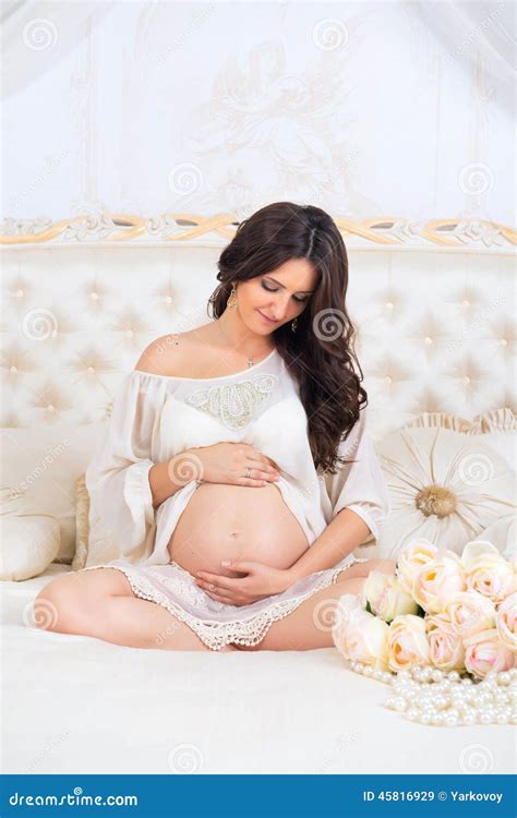 Beautiful Pregnant Brunette Sitting On A Bed In The Lotus Position Stock Image Image Of