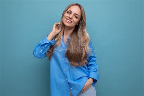 Stylish Casual Blonde Girl Flirts And Smiles On A Blue Isolated Background Stock Photo Image