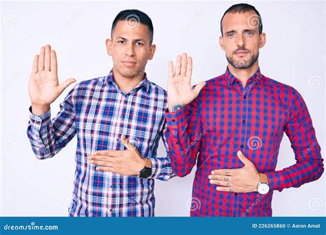 Joven Pareja Gay De Dos Hombres Con Ropa Casual Jurando Con La Mano En El Pecho Y La Palma