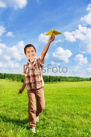 Фотография на тему Счастливый мальчик бросает бумажный самолет | PressFoto