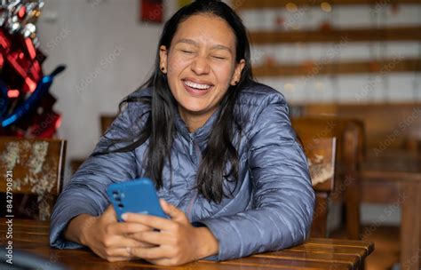mujer latina hispana joven con el pelo largo que sonríe feliz mientras esta sentada en el
