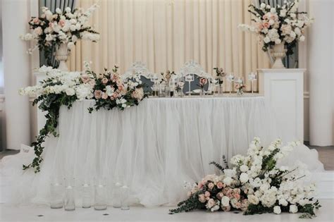 Una Mesa Con Flores Y Un Mantel Blanco Foto Premium