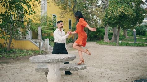 Artistas Sensuales Bailando Coreograf A Latina En El Parque Mujer Girando En El Banco Foto Premium