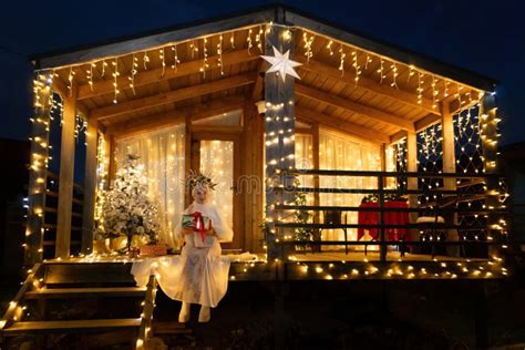 Happy Blonde As Snow Maiden In White Costume Wooden House Exterior Festive Setting Stock Photo