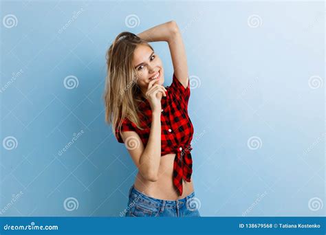 Belle Jeune Fille Blonde Joyeuse Utilisant La Chemise Et Les Blues jean à Carreaux Rouges Rire