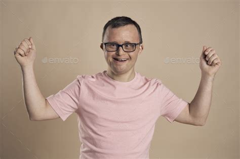 Man With Down Syndrome Celebrating Success At Nude Background Stock Photo By Gpointstudio