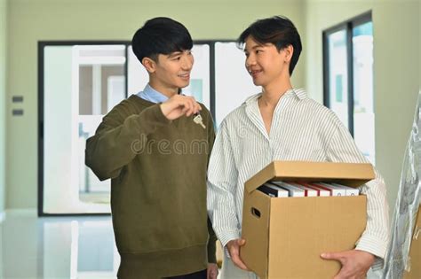 Happy Asian Gay Couple Holding Cardboard Box And Sowing Key Of New Home LGBTQ Relocation And