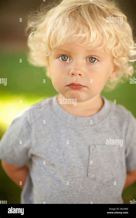 Close up portrait of blonde innocente bébé garçon avec des cheveux bouclés en t shirt gris Photo