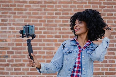 Joven latina hispana afroamericana mujer haitiana sonriendo grabándose a sí misma con su