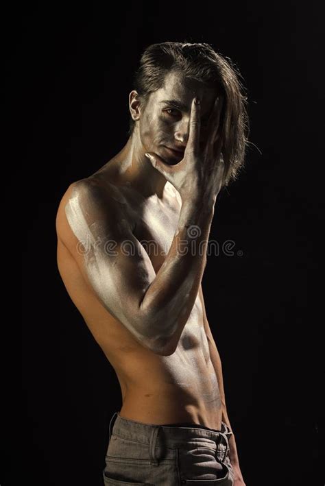 Man With Nude Torso Covered With Shimmering Silver Paint Stock Photo