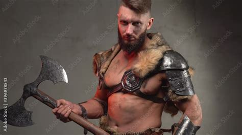 Holding Two Handed Axe Scandinavian Barbarian With Muscular Build And Naked Torso In Light