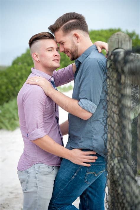 Pareja Gay Asiática Parada Y Abrazándose Cerca De La Ventana En Casa Jóvenes LGBTQ Hombres