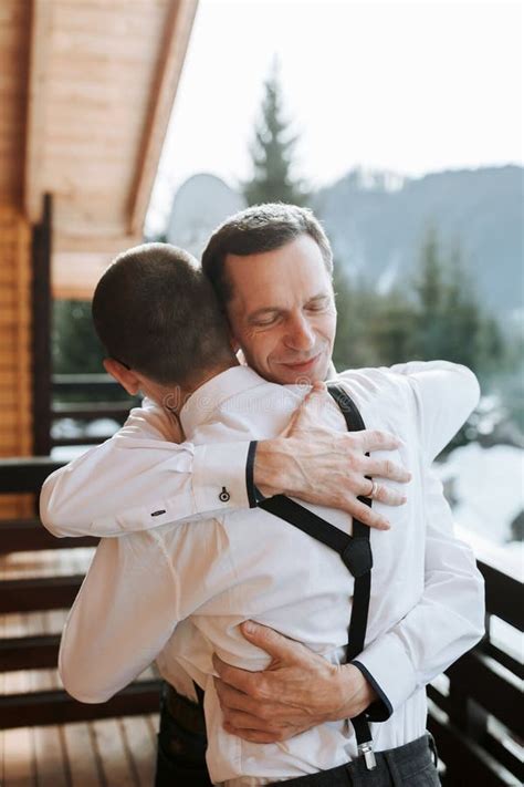 A Respectful Father Helps His Mature Son Put On A Bow Tie Before The