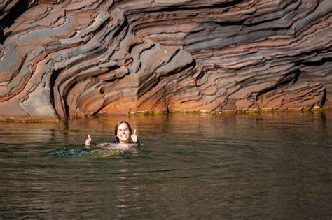 Ein langhaariges Mädchen in einem weißen Bikini nimmt ein erfrischendes Bad in einem