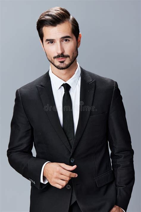 Un Hombre Con Barba De Brunette Traje De Negocios Camisa Blanca Y Corbata Posa Contra Un Fondo