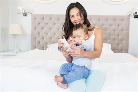 Happy Brunette Holding Her Baby And Using Smartphone Stock Image Image Of Interior Happy
