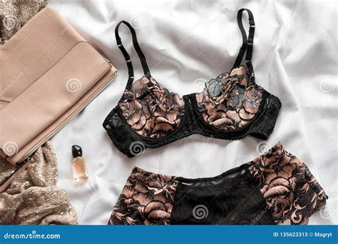 Set Of Glamorous Stylish Lace Lingerie With Woman Accessories On White Bedsheets Background