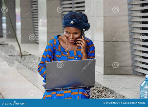 Portrait Of A Beautiful Mature Businesswoman With Laptop Smiling At Mobile Phone Stock Photo