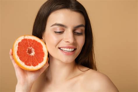 Gros Plan Femme Moiti Nue Avec Une Peau Parfaite Maquillage Nude Tient Pamplemousse Isol Sur