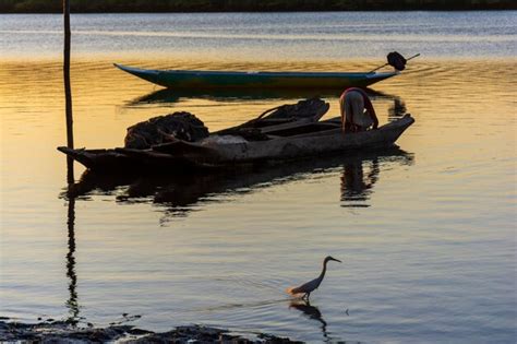 Silueta Al Atardecer De Un Pescador En Su Canoa Atracado En El