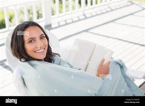 Pretty Brunette Sitting On A Chair And Reading A Book Stock Photo Alamy