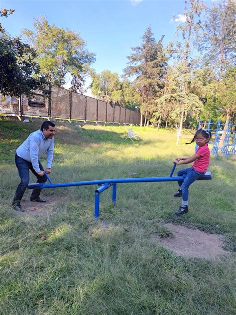 Divorced Dad Plays With His Brunette Latina Daughter On The Seesaw In