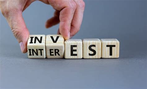 Invest Or Interest Symbol Businessman Turns Wooden Cubes And Changes