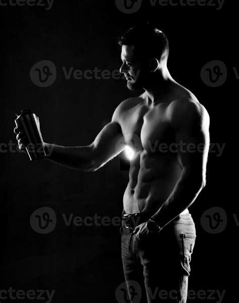 Photo Of Half Naked Sportsman Holding Sport Bottle Of Water Half Turned To The Camera Black