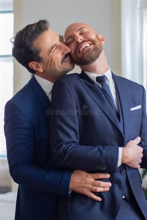 Happy Gay In Official Suits Hugging And Kissing In Hotel Room Stock Photo Image Of Lgbt