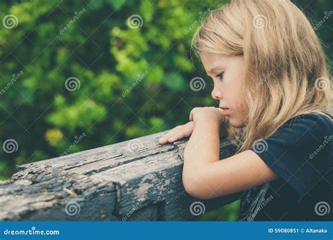 Portrait De La Petite Fille Blonde Triste Sasseyant Sur Le Pont Image