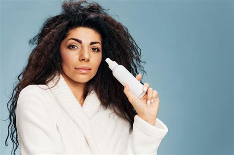 Sonriente Dama Latina Bastante Rizada En Bata De Ba O Sostiene Una Botella De Spray De T Ner