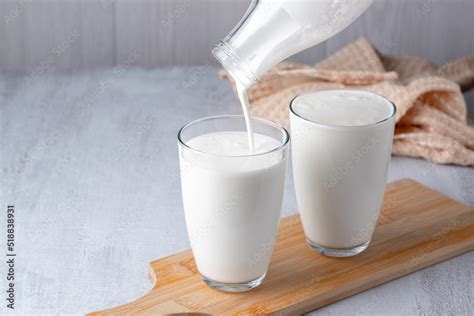 Pouring Homemade Kefir Buttermilk Or Yogurt With Probiotics Yogurt Flowing From Glass Bottle