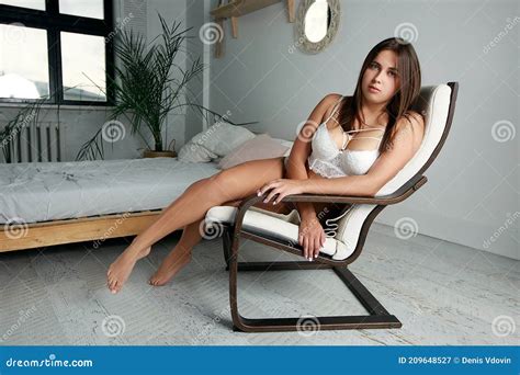 Beautiful Lady In Elegant White Lingerie Sitting On A Chair In Her Bedroom Stock Image Image