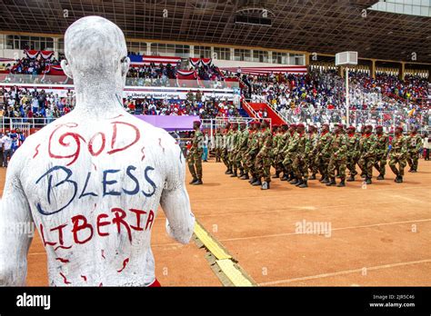 A Liberian artist paints his shirt with the national colours and the