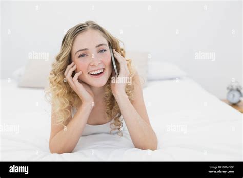 Pretty Smiling Blonde Lying On Bed Phoning Stock Photo Alamy