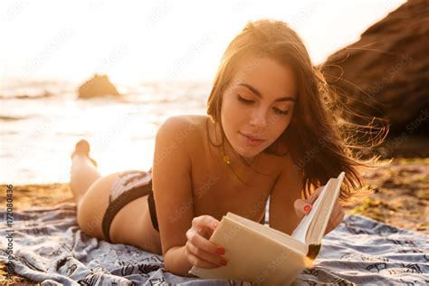 Pretty brunette woman in bikini lying on beach Фотографія Stock Adobe Stock
