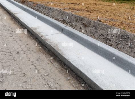 Road Construction Details Extruded Concrete Curb Beside Freshly