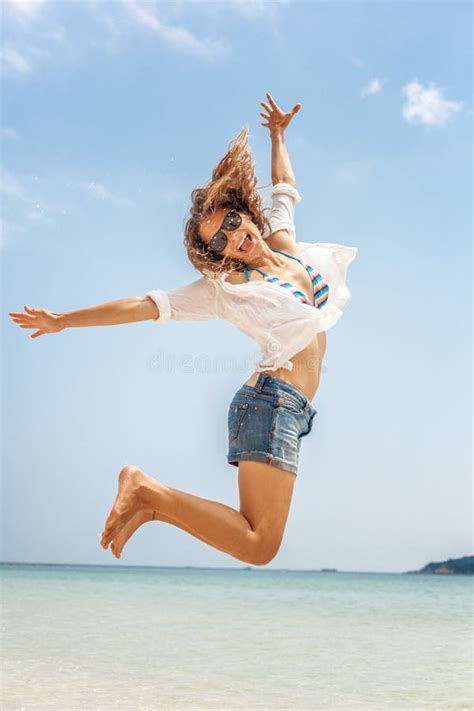 Mujer Joven Hermosa En Bikini Y Pantalones Cortos Que Saltan En La Orilla Foto De Archivo