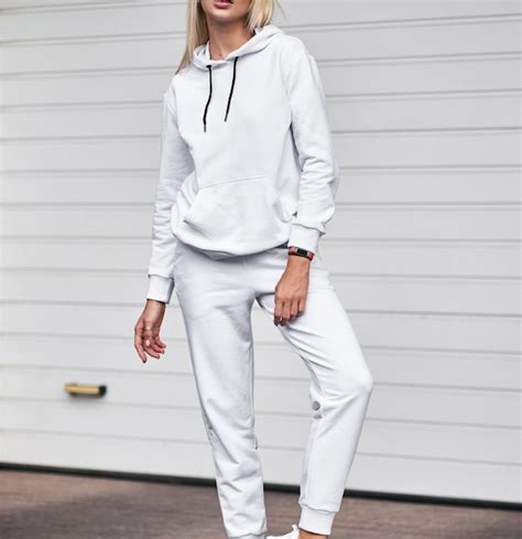 Femme est debout en costume blanc Streetwear élégant sans logos ni images sur une fille blonde