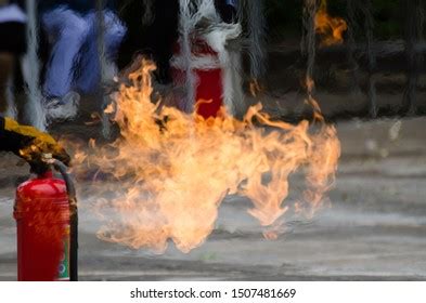 Man Using Fire Extinguisher Fighting Fire Stock Photo