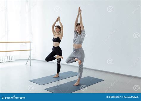 Two Young Beautiful Girls Do Yoga Asana Tree Pose Stock Image Image