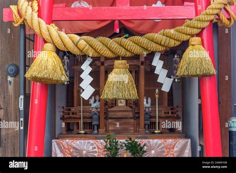 Sacred Rope Or Shimenawa On Red Vermillion Torii Gate To Small Local