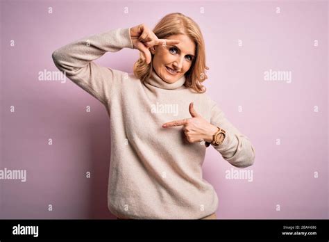 Middle Age Beautiful Blonde Woman Wearing Casual Turtleneck Sweater Over Pink Background Smiling